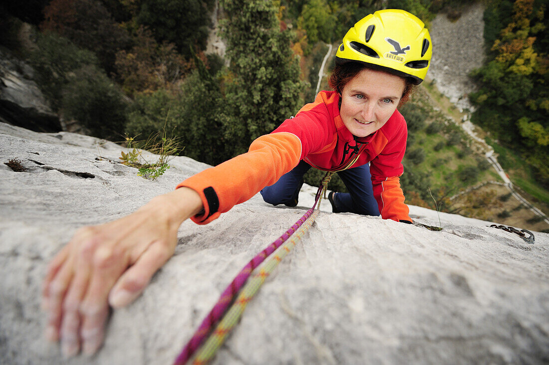 Woman climbing on rock face, Torbole-Nago, Lake Garda, Trentino-Alto Adige/South Tyrol, Italy