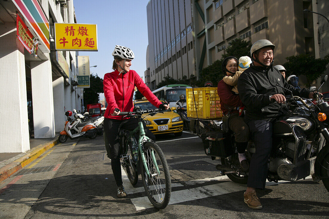 Junge deutsche Fahrradfahrerin und Familie auf Motorrad, Taipeh, Republik China, Taiwan, Asien