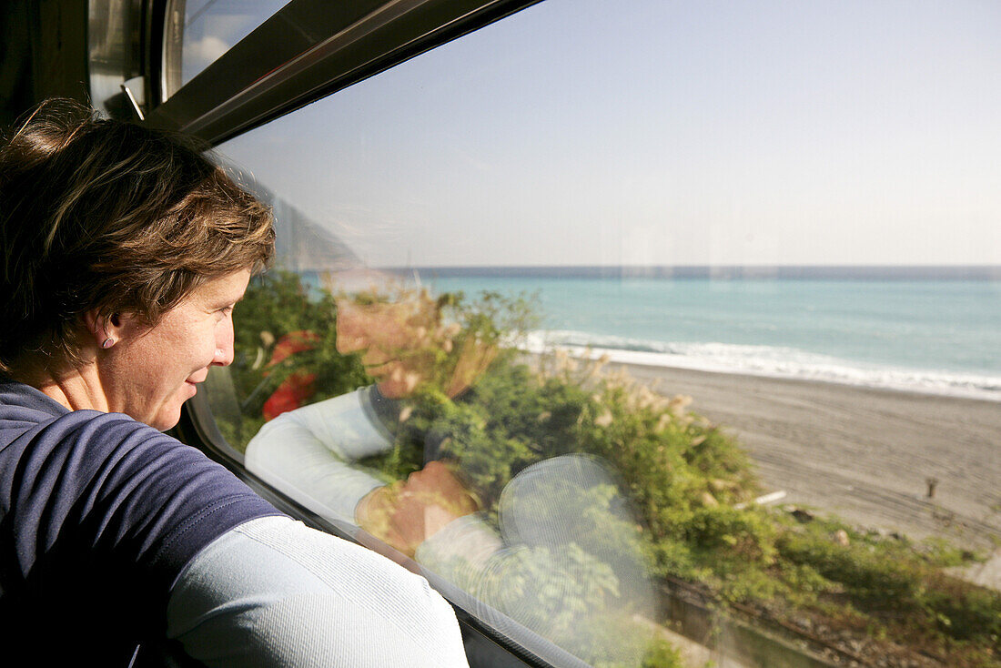 Junge deutsche Frau im Zug am Fenster, Blick auf Meer und Strand, Hualien, Republik China, Taiwan, Asien