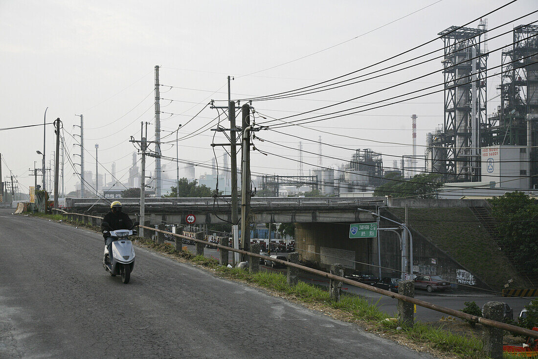 Man on scooter on a road next to chemical plant, west coast, Republic of China, Taiwan, Asia