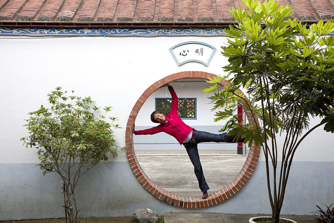 German tourist inside the moon gate of a temple, Tainan, Republic of China, Taiwan, Asia