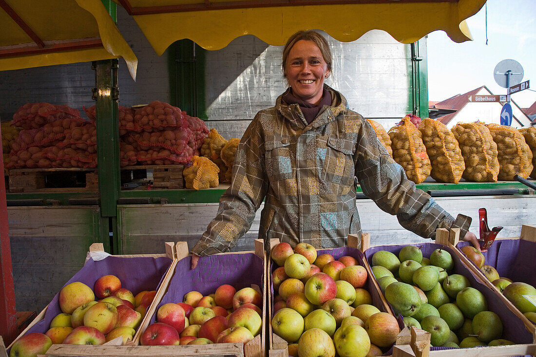 Obst- und Gemüsemarkt auf dem Marktplatz in Springe, Verkaufsstand mit Äpfeln und Kartoffeln, Verkäuferin