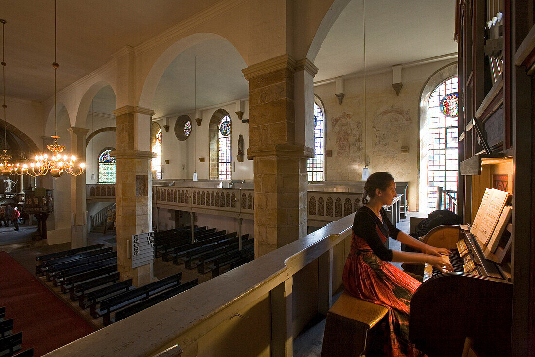 Kloster Wennigsen, Orgelspielerin in der Klosterkirche, Orgel, Kronleuchter, Kirchenschiff, Kirchenbänke, Ornamentfenster, Säülen