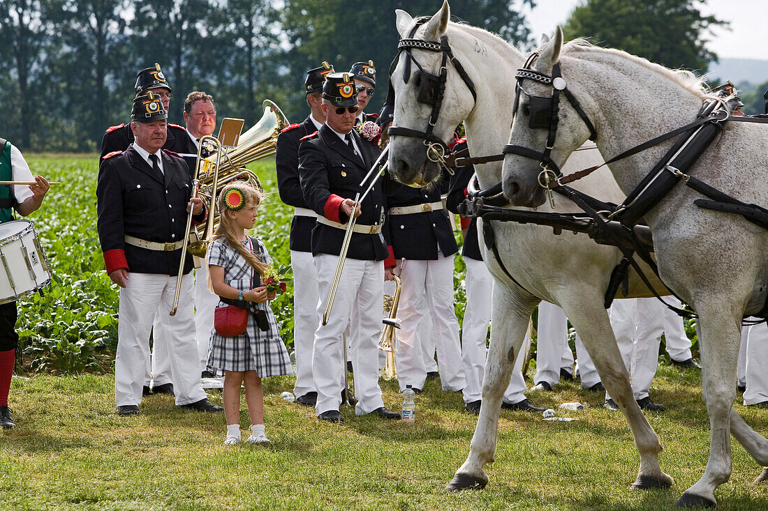 Traditioneller Schützenausmarsch beim Freischiessen in Wennigsen, angetretene Schützen in Uniform, Federbusch, Kapelle, Mädchen als Zuschauer, Musikinstumente, Trommel, Tuba, Zuschauerin, Pferdekutsche, Bäume, Wiese