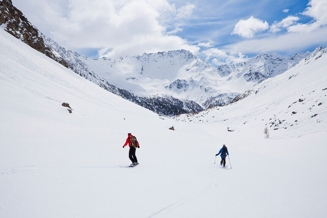 Skier and snowboarder on slope, Puschlav, Grisons, Switzerland