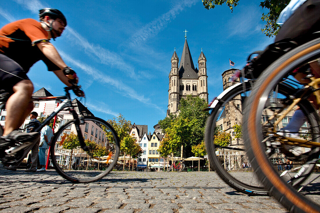 Cyclists near church Great St. Martin, Old town, Cologne, North Rhine-Westphalia, Germany