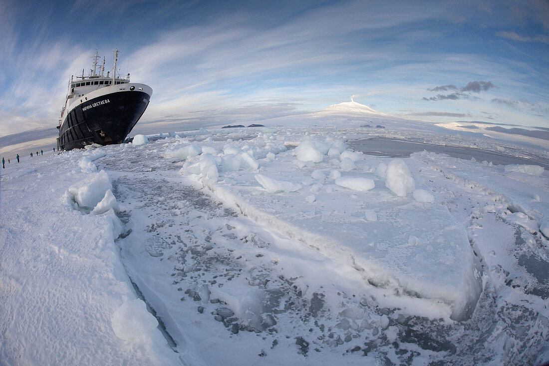 Marina Svetaeva,  Ice_strengthened Russian cruise ship ( Aurora Expeditions) in McMurdo Sound sea ice _ volcano Mt Erebus behind_ volcano Mt Erebus behind