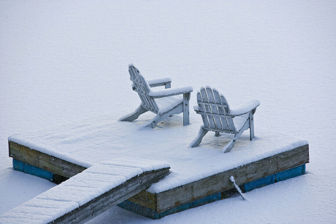 Snow covered adirondack chairs