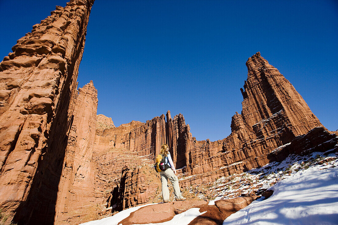 Female hiker admires the beautiful sandstone spires from trail at Fisher Towers outside Moab,  Utah,  USA