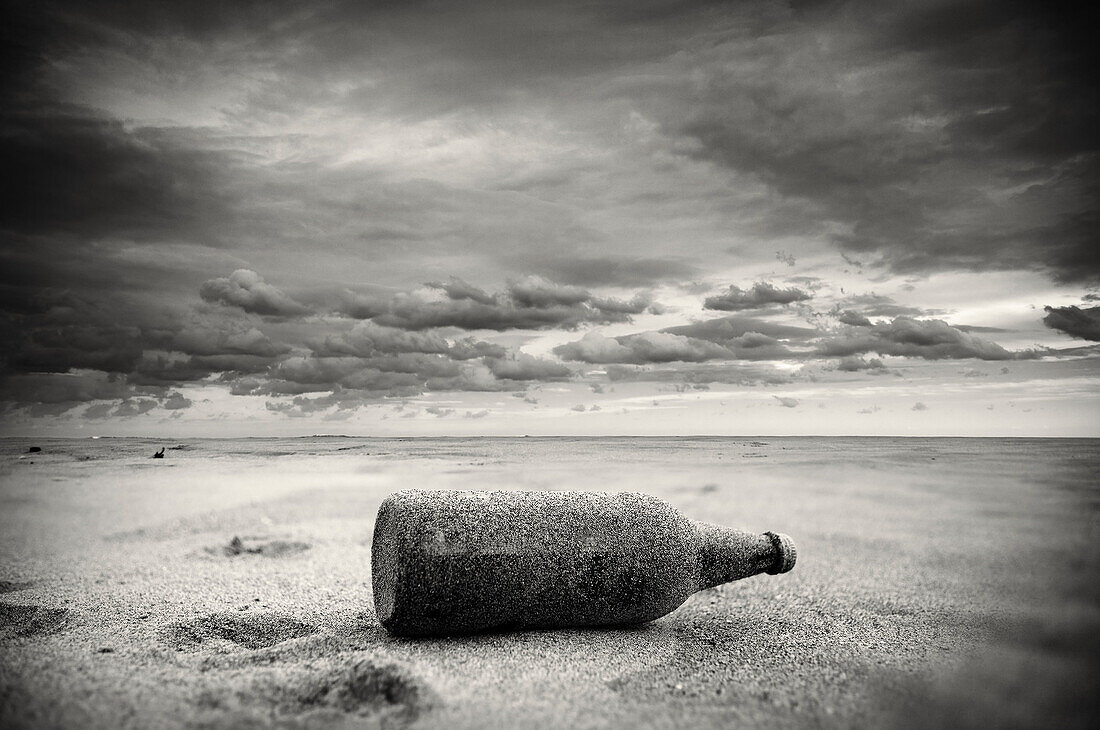 Bottle left in the sand of the beach after the storm