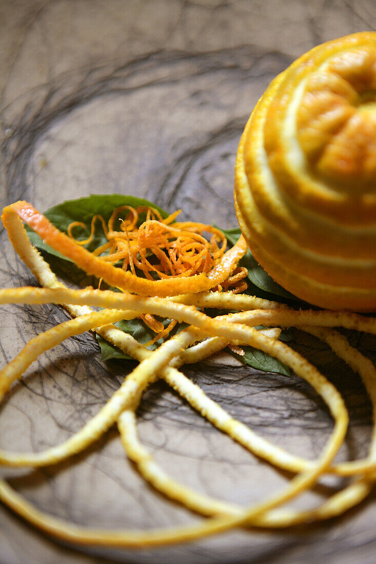 Zubereitetes Gericht mit Orangenfrüchten in einer Tonschale