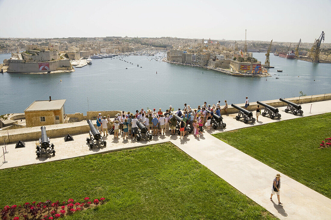 Tourists visiting Saluting Battery,  overlooking Grand Harbour,  from Upper Barracca Gardens,  Valletta,  Malta