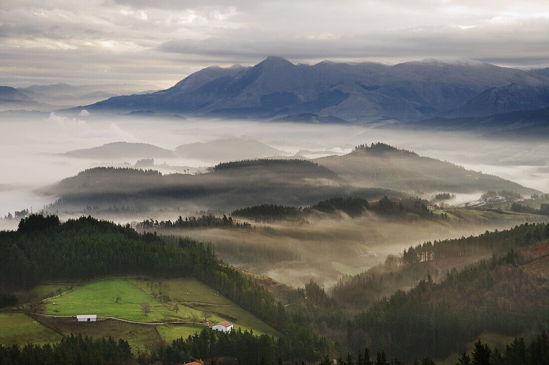 Fog over Goierri valley with Txindoki mountain of the Aralar mountain range in background. Guipuzcoa,  Basque Country,  Spain