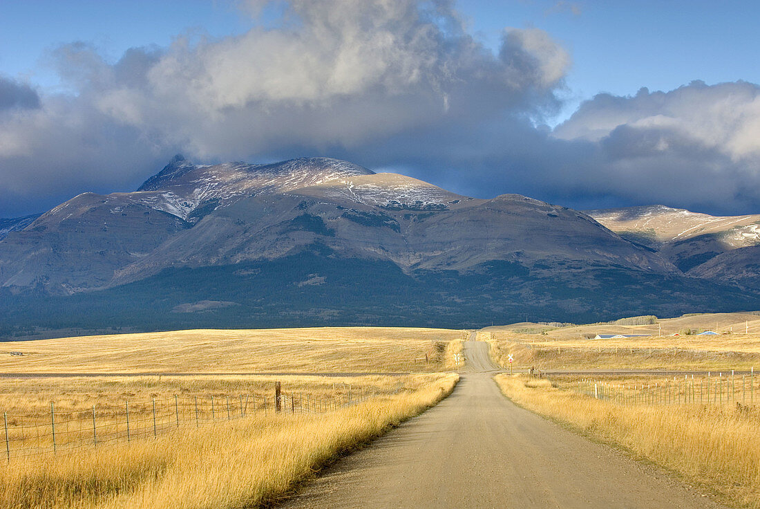 Road on the Montana plains near the Rocky Mountain Front Ranges of Glacier National Park USA