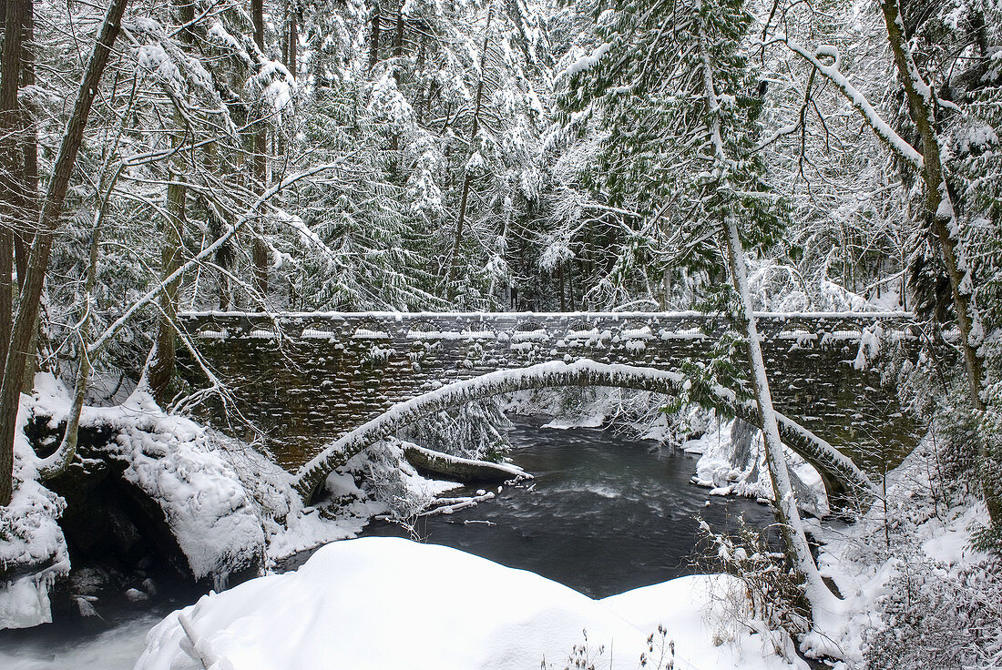 Stone bridge over Whatcom Creek after fresh snowfall,  Bellingham Washington USA