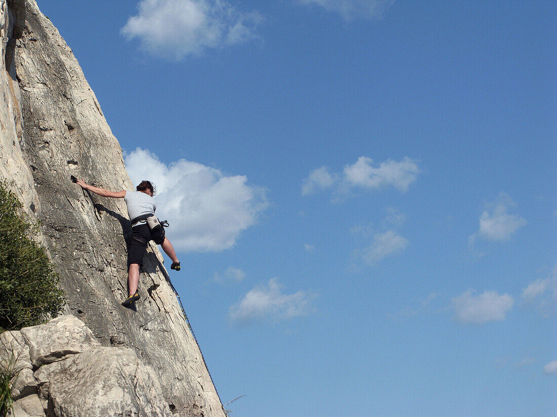 adult woman climb a natural rock wall