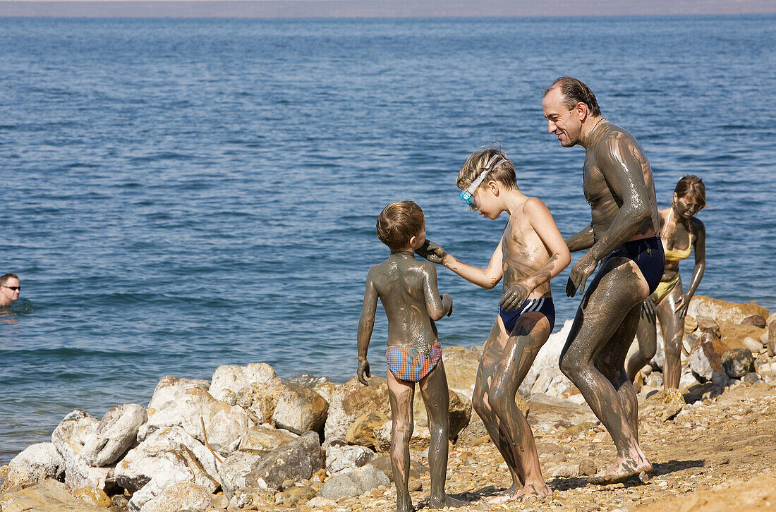 Jordan,  Dead Sea People on the beach with Dead Sea mud on their bodies