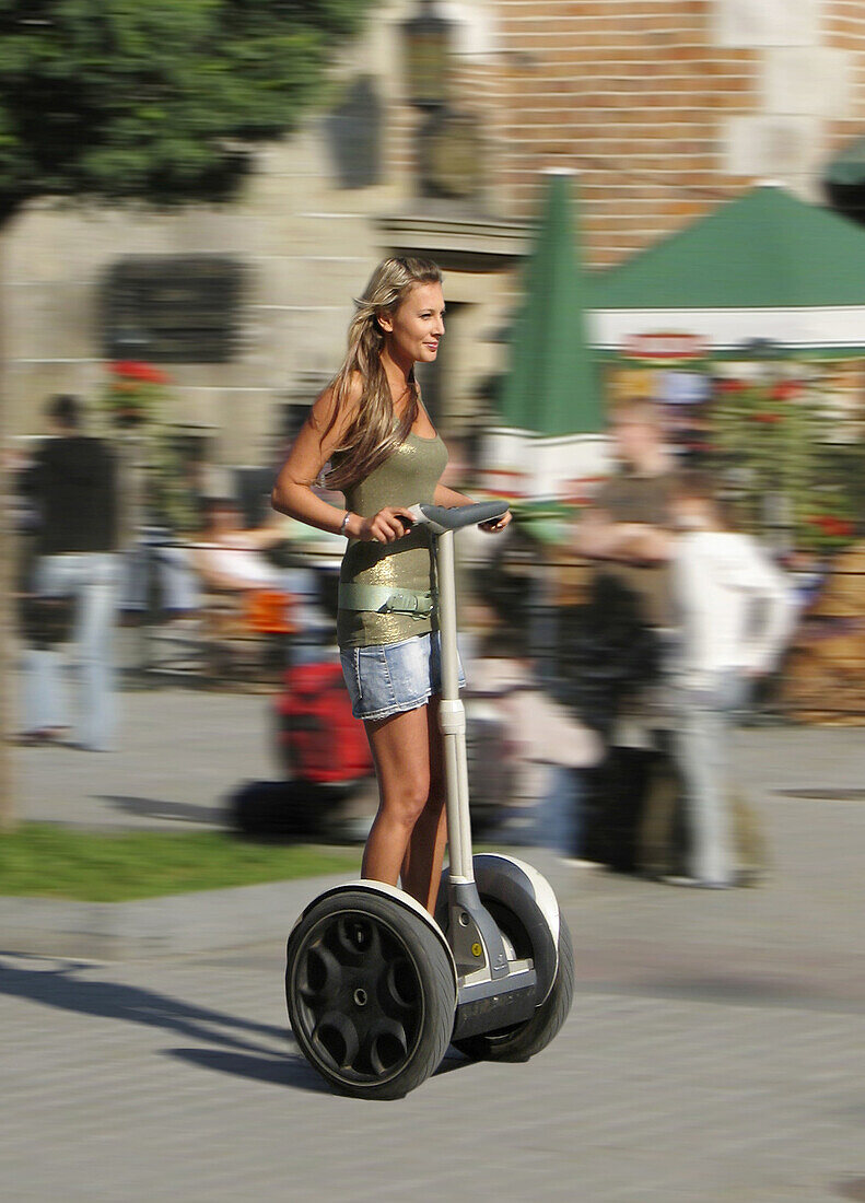 Poland Krakow,  Main Market Square,  woman rides sagway