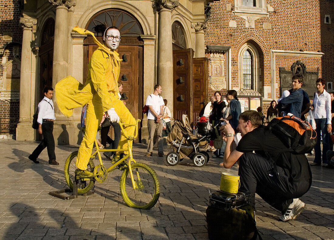 Funny street performer on bicycle at Main Market Square,  Krakow,  Poland