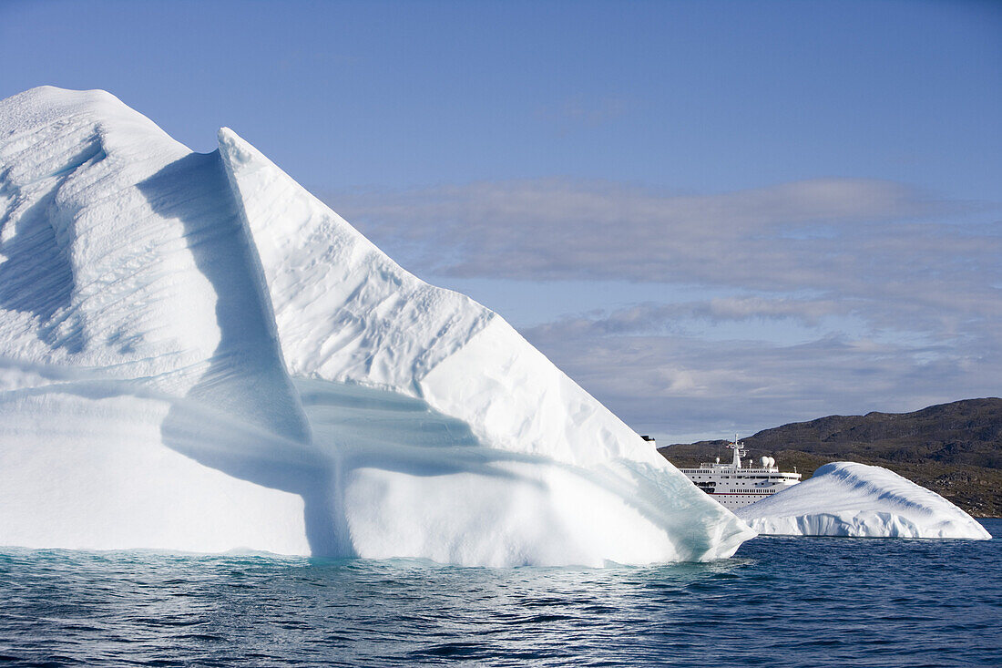 Eisberg und Kreuzfahrtschiff MS Deutschland im Sonnenlicht, Kitaa, Grönland