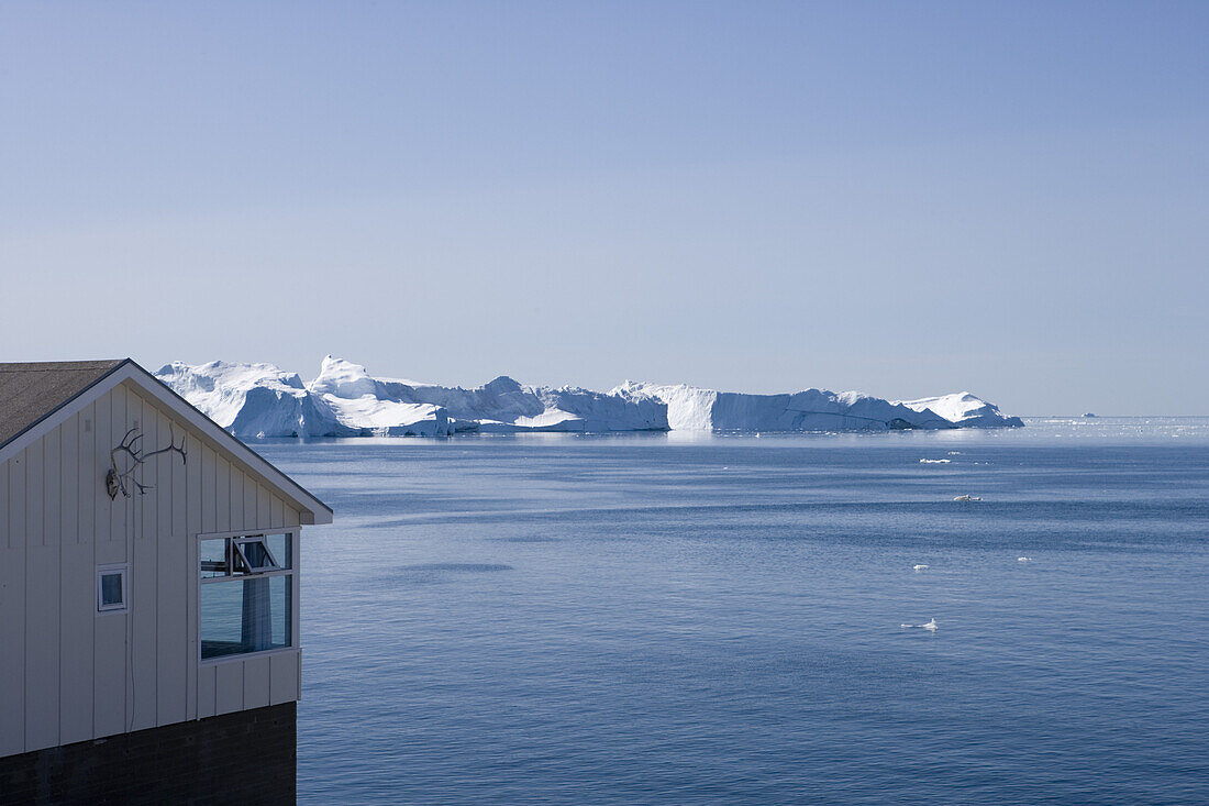 Haus mit Blick auf Eisberge vom Ilulissat Kangerlua Isfjord, Ilulissat (Jakobshavn), Diskobucht, Kitaa, Grönland