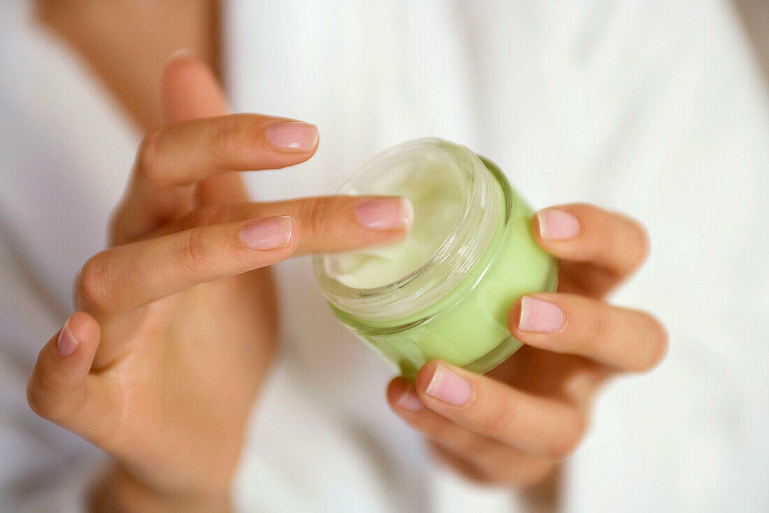 Woman´s hands holding a cosmetic container