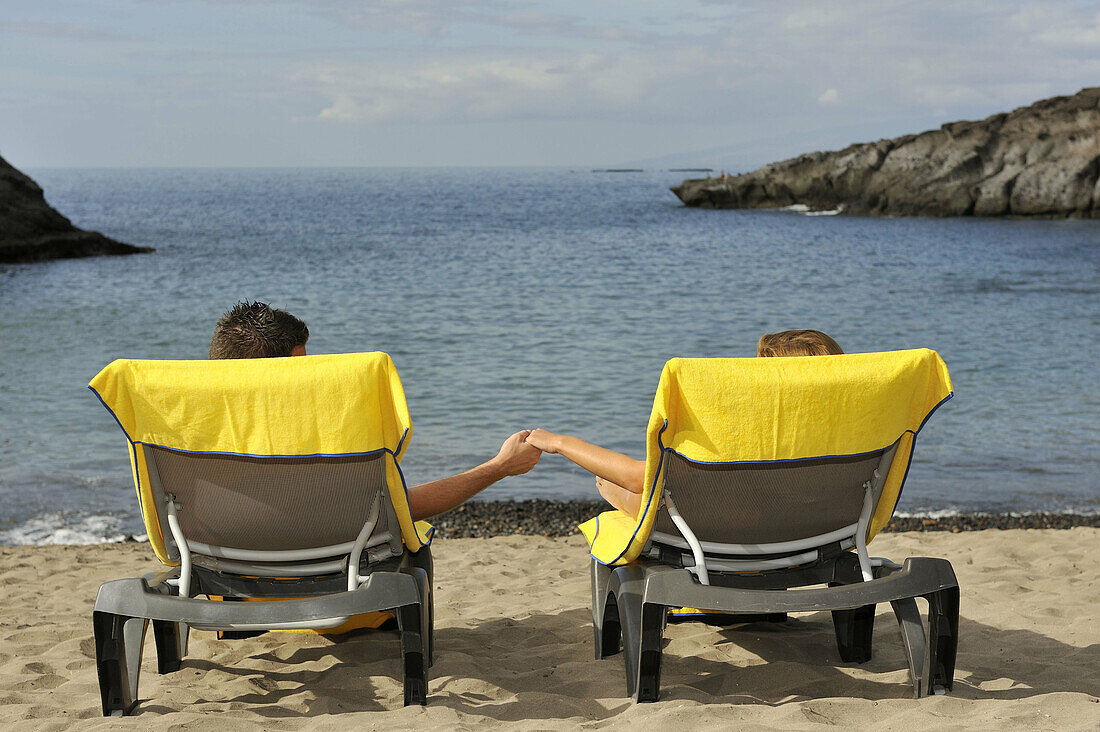 Couple sunbathing on the beach,  Canary Islands,  Spain