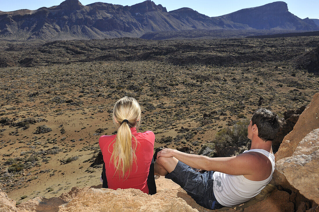 Boys sitting watching the valley of the volcano Teide.