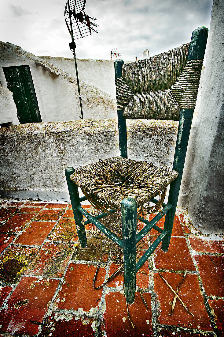 Silla de esparto rota en los tejados de Binibeca,  Menorca,  Islas Baleares,  Spain