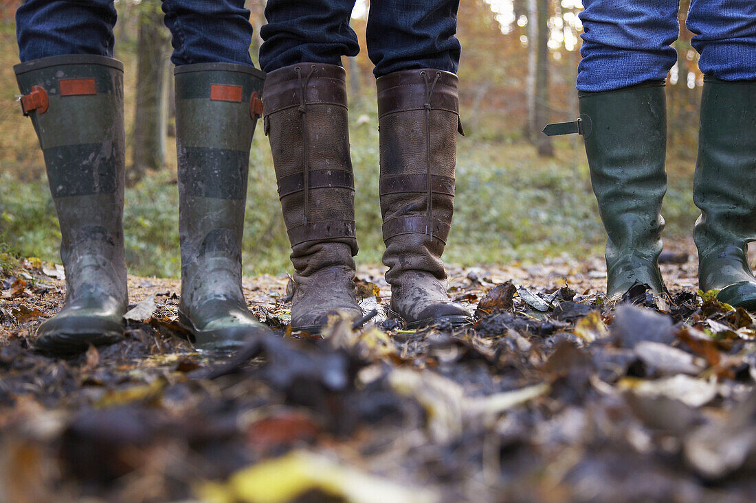 Three women in wellington boots in a forest