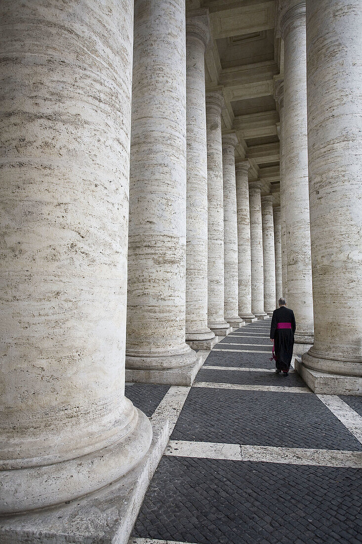 Man between the columns of the Bernini´s colonnade,  Vatican City,  Rome,  Italy