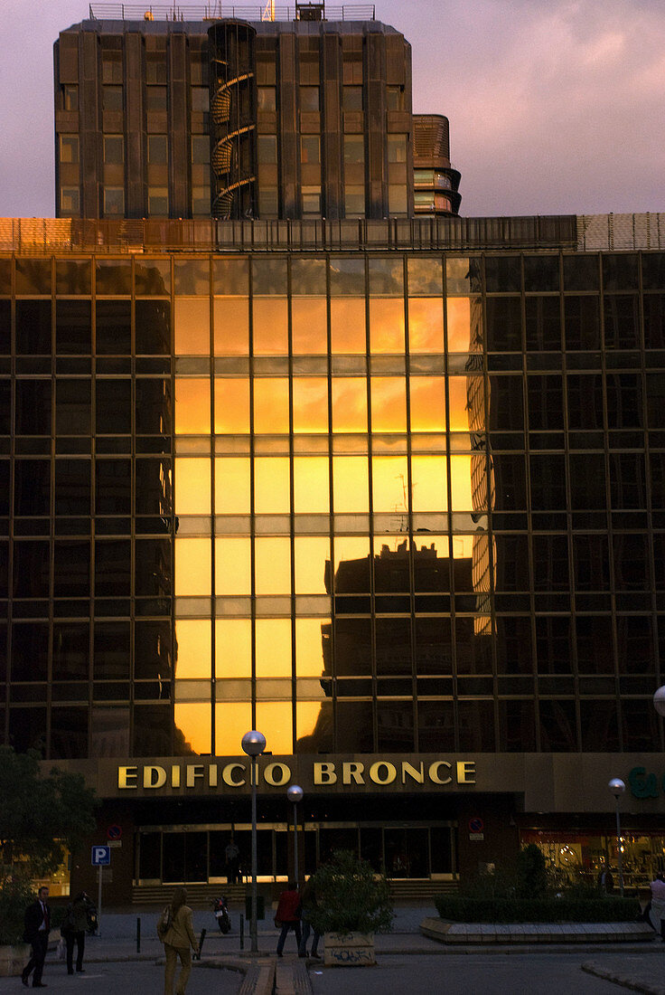 Sunset reflects on Edificio Bronce (´bronze building´),  making its name stand true,  Madrid. Spain