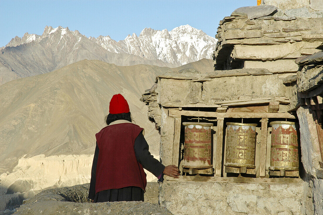 Tibetan woman spinning prayer wheels Lama Yuru,  Ladakh,  India