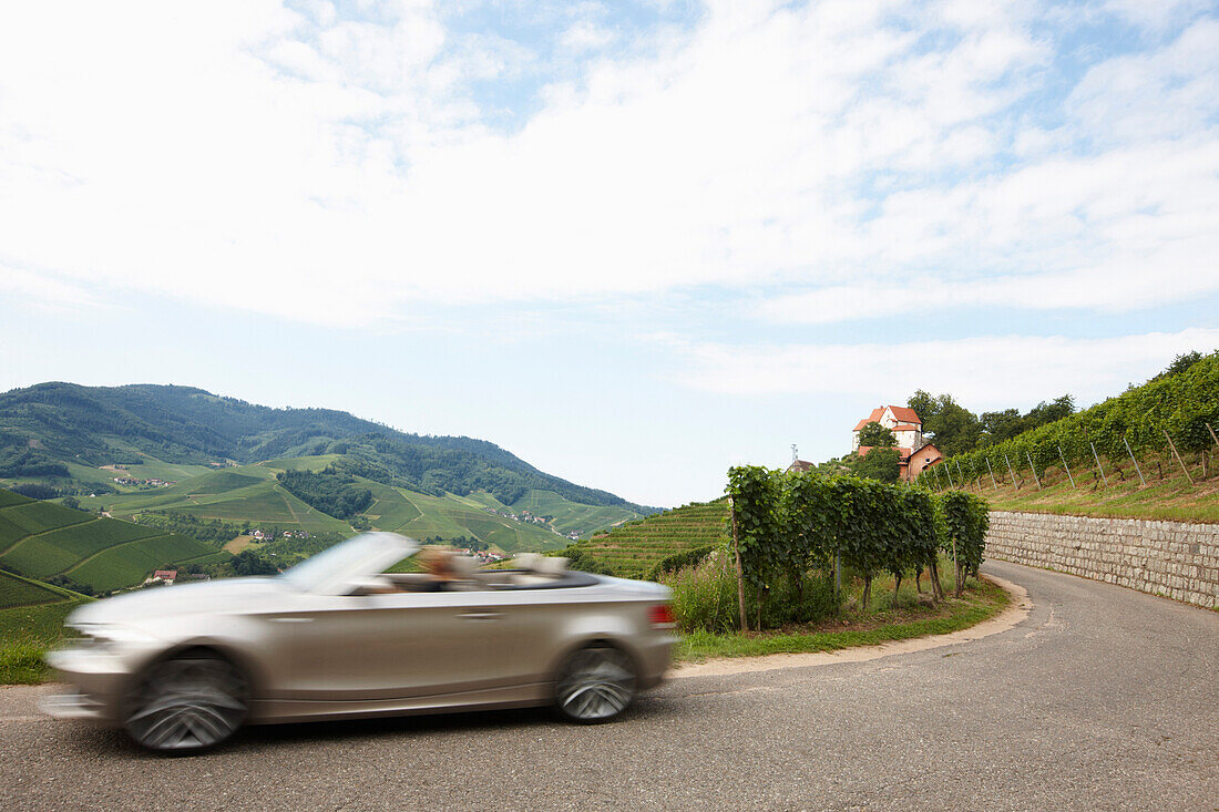 Convertible passing country road, Durbach-Staufenberg, Black Forest, Baden-Wuerttemberg, Germany