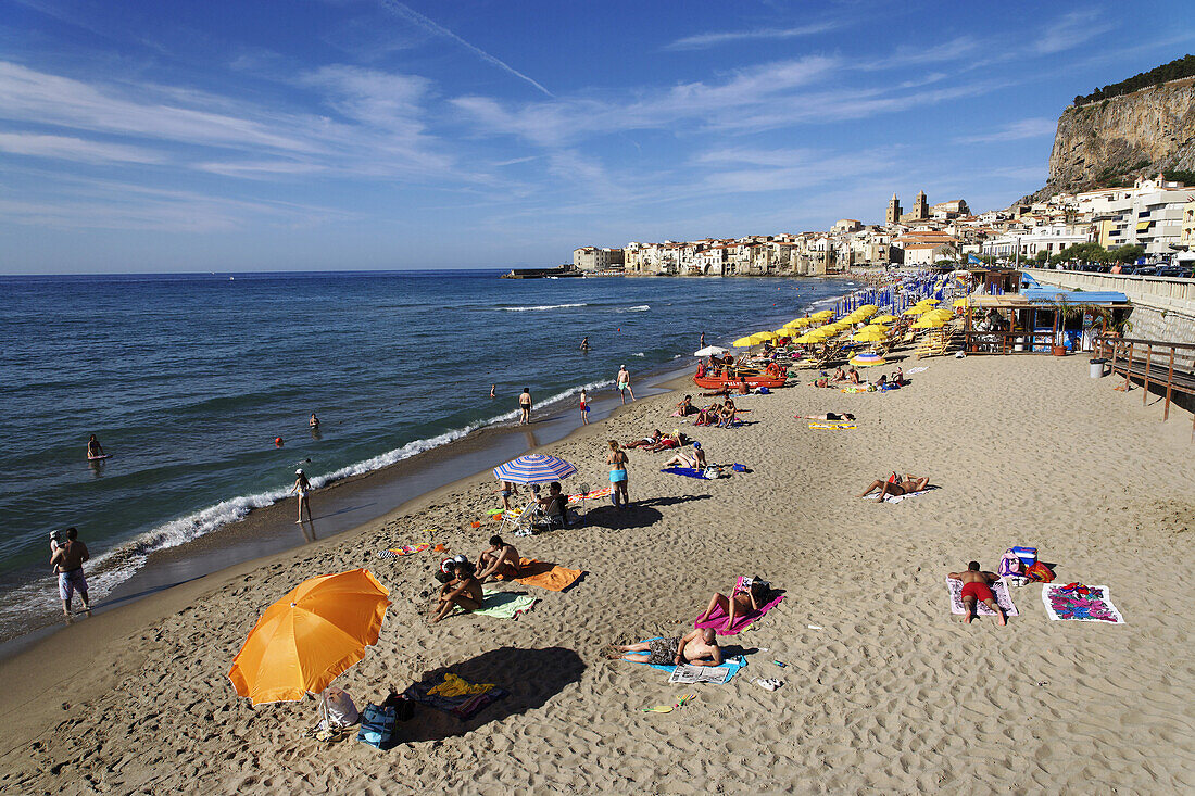 View along beach to Cefalu with Duomo in background, Sicily, Italy