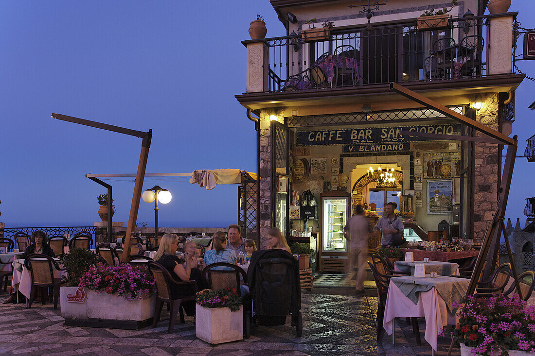 Guests in a pavement cafe in the evening, Castelmola, Sicily, Italy
