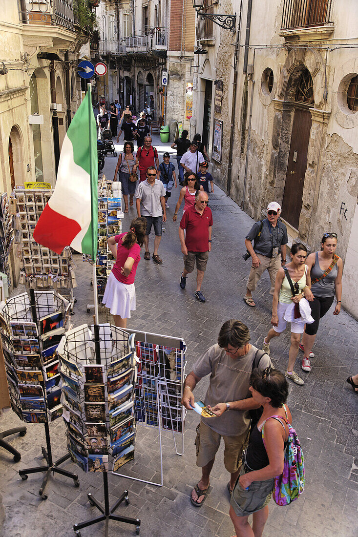 Tourists strolling along shopping street, Syracuse, Sicily, Italy