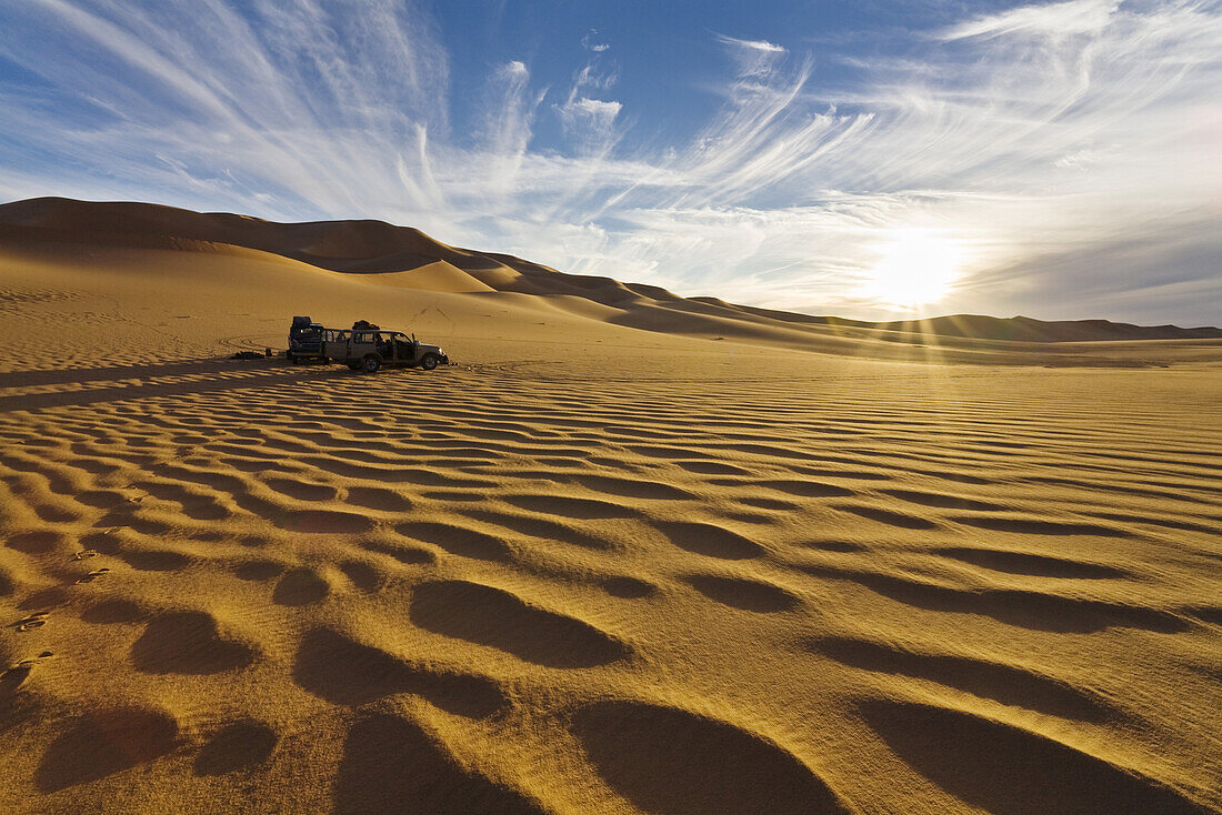 Jeeps in Sanddünen der libyschen Wüste bei Sonnenuntergang, Erg Murzuk, Libyen, Sahara, Nordafrika