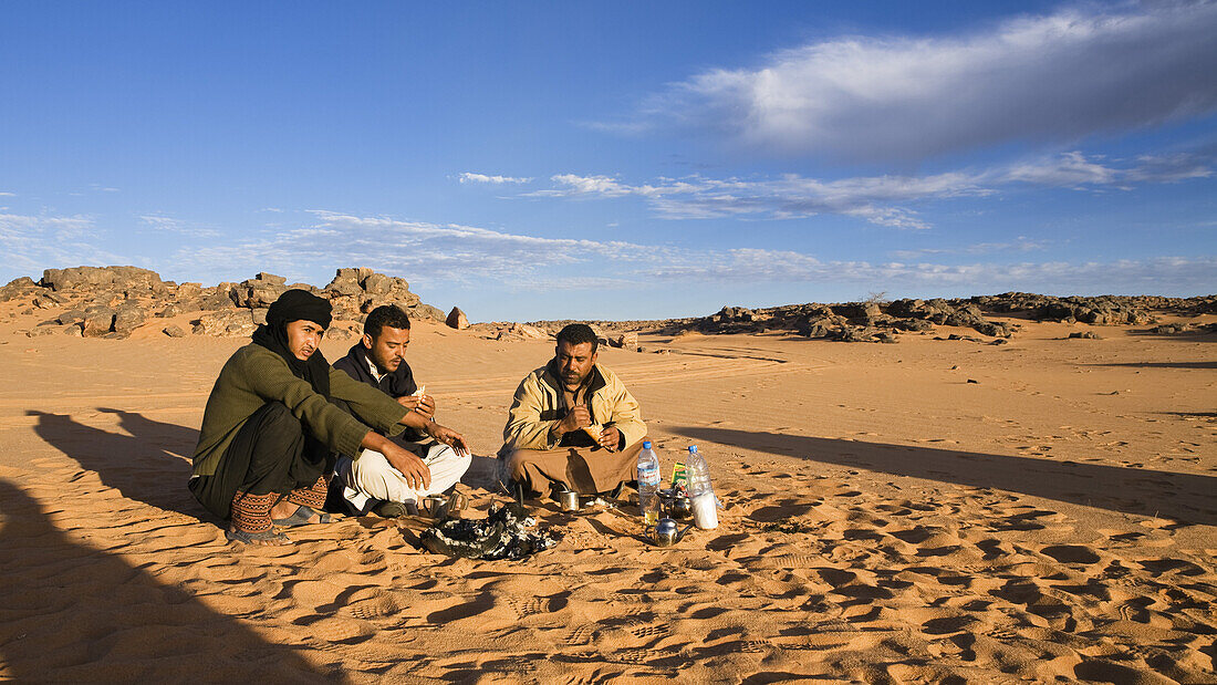 beduins having breakfast at campfire, Akakus mountains, Libya, Sahara, Africa