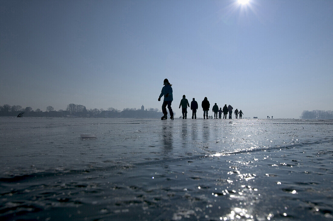 Eiswanderung auf dem zugefrorenen Chiemsee, im Hintergrund die Fraueninsel, Chiemsee, Chiemgau, Bayern, Deutschland