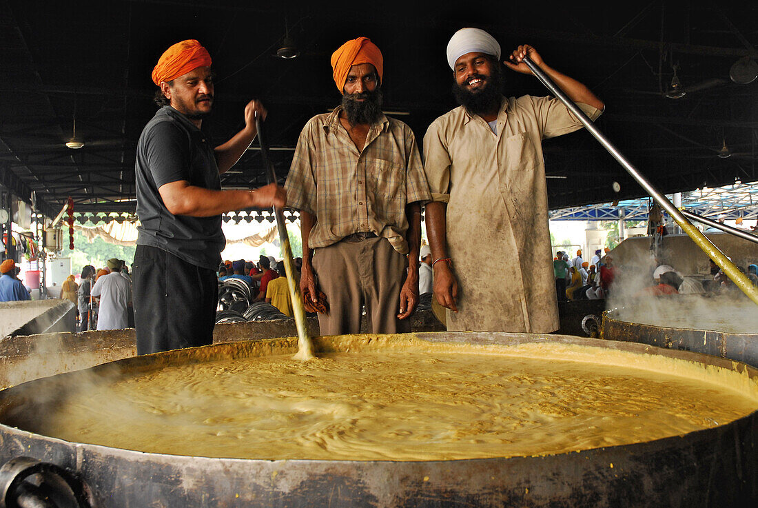 Goldener Tempel, drei Sikh Männer an riesigem Topf, kostenlose Speisung für Pilger, Heiligtum der Sikhs, Amritsar, Punjab, Indien, Asien