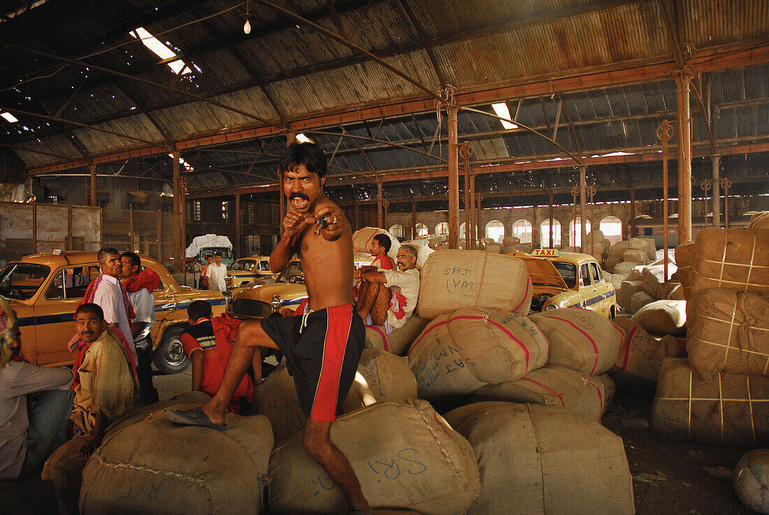 Men at a warehouse at Howrah Station in the evening, Howrah, India, Asia
