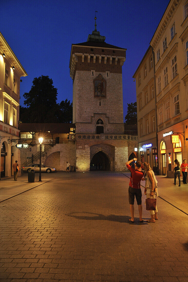 Tourists taking picture of the Ccity gate in the evening, fortress Barbakan, Krakow, Poland, Europe