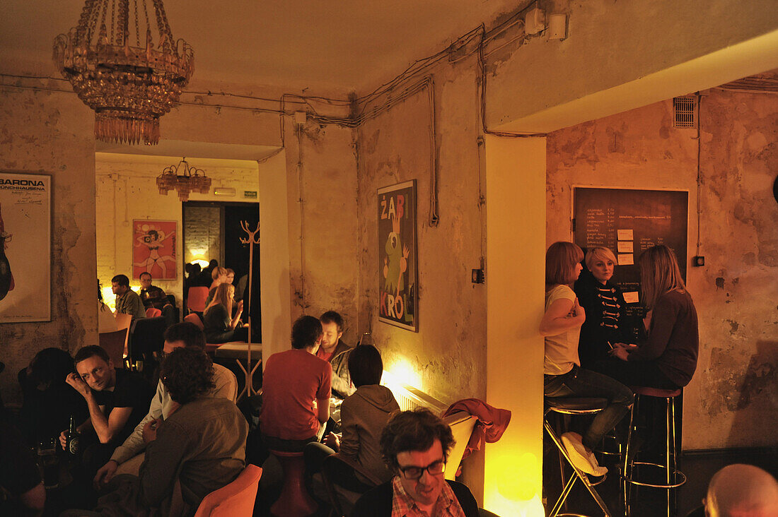 People at the meagerly furnished students pub Miejsce, Kazimierz, Krakow, Poland, Europe