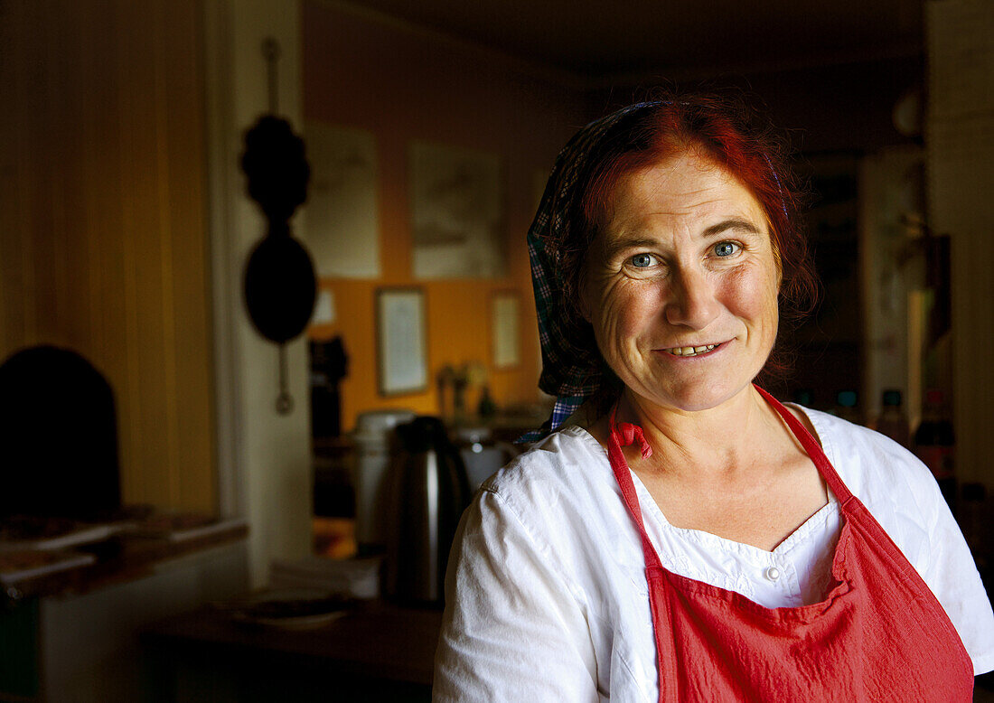 Lächelnde Kellnerin im Café des Rallarmuseum, Finse, Nationalpark Hardangervidda, Hordaland, Südnorwegen, Norwegen, Skandinavien; blickt in die Kamera; Portrait, Frau, Europa