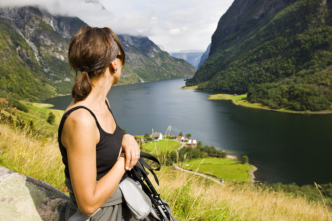 Junge Frau schaut auf den Naerofjord, Sogn og Fjordane, Norwegen, Skandinavien, Europa