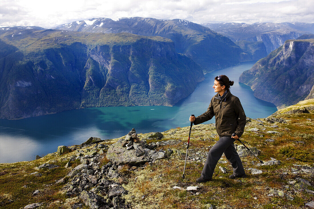 Junge Frau wandert mit Blick auf den Aurlandsfjord, Prest, Aurland, Sogn og Fjordane, Norwegen, Skandinavien, Europa