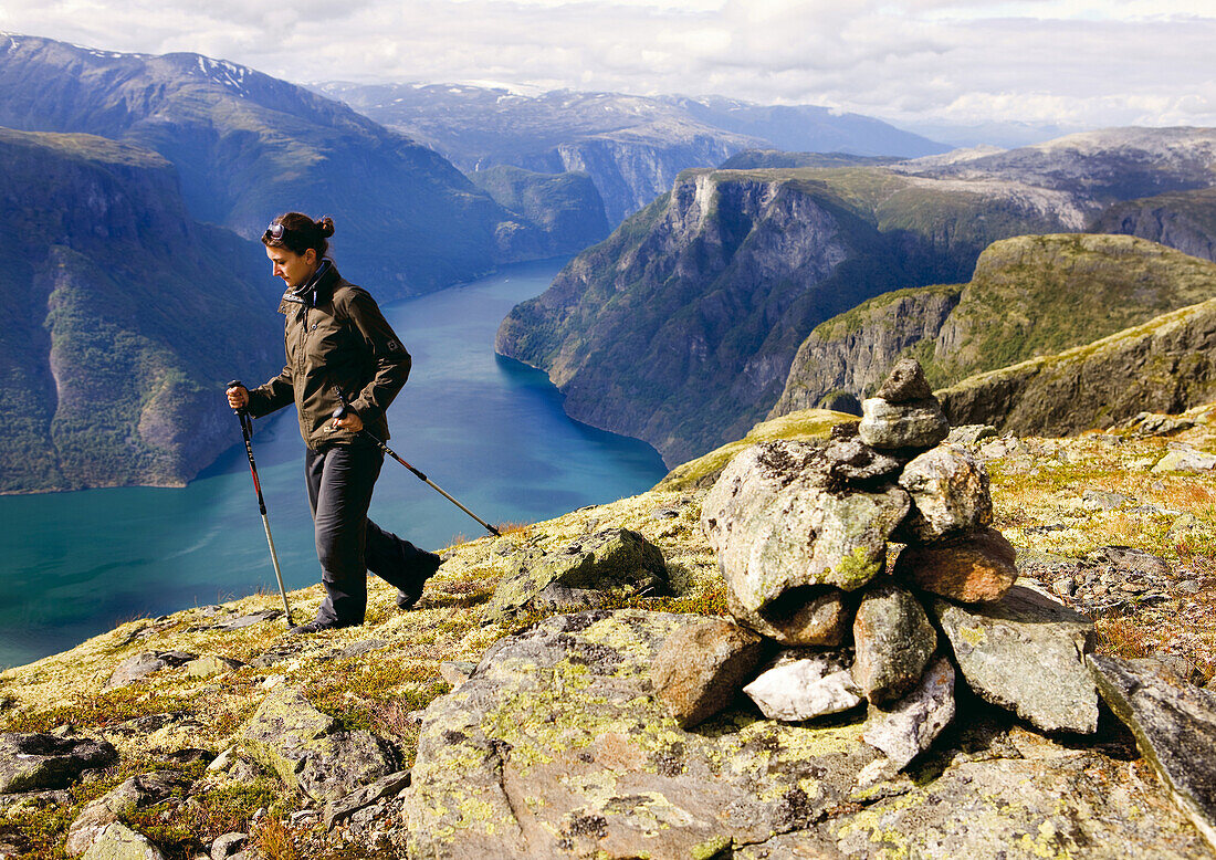 Junge Frau wandert mit Blick auf den Aurlandsfjord, Prest, Aurland, Sogn og Fjordane, Norwegen, Skandinavien, Europa