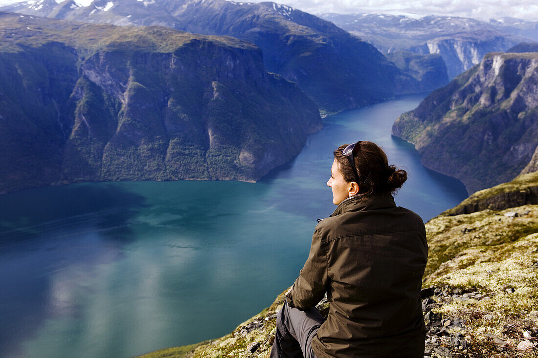 Junge Frau schaut auf den Aurlandsfjord, Prest, Aurland, Sogn og Fjordane, Norwegen, Skandinavien, Europa
