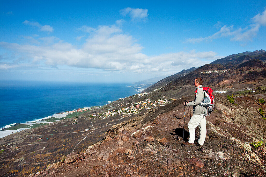 Hiker at volcano crater looking at the sea, Volcano San Antonio, Fuencaliente, La Palma, Canary Islands, Spain, Europe